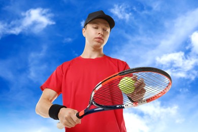 Image of Man playing tennis against blue sky with clouds, low angle view