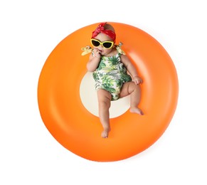 Photo of Cute little baby in sunglasses with inflatable ring on white background, top view