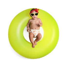 Photo of Cute little baby in sunglasses with inflatable ring on white background, top view