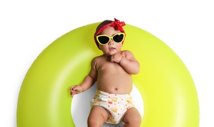 Photo of Cute little baby in sunglasses with inflatable ring on white background, top view