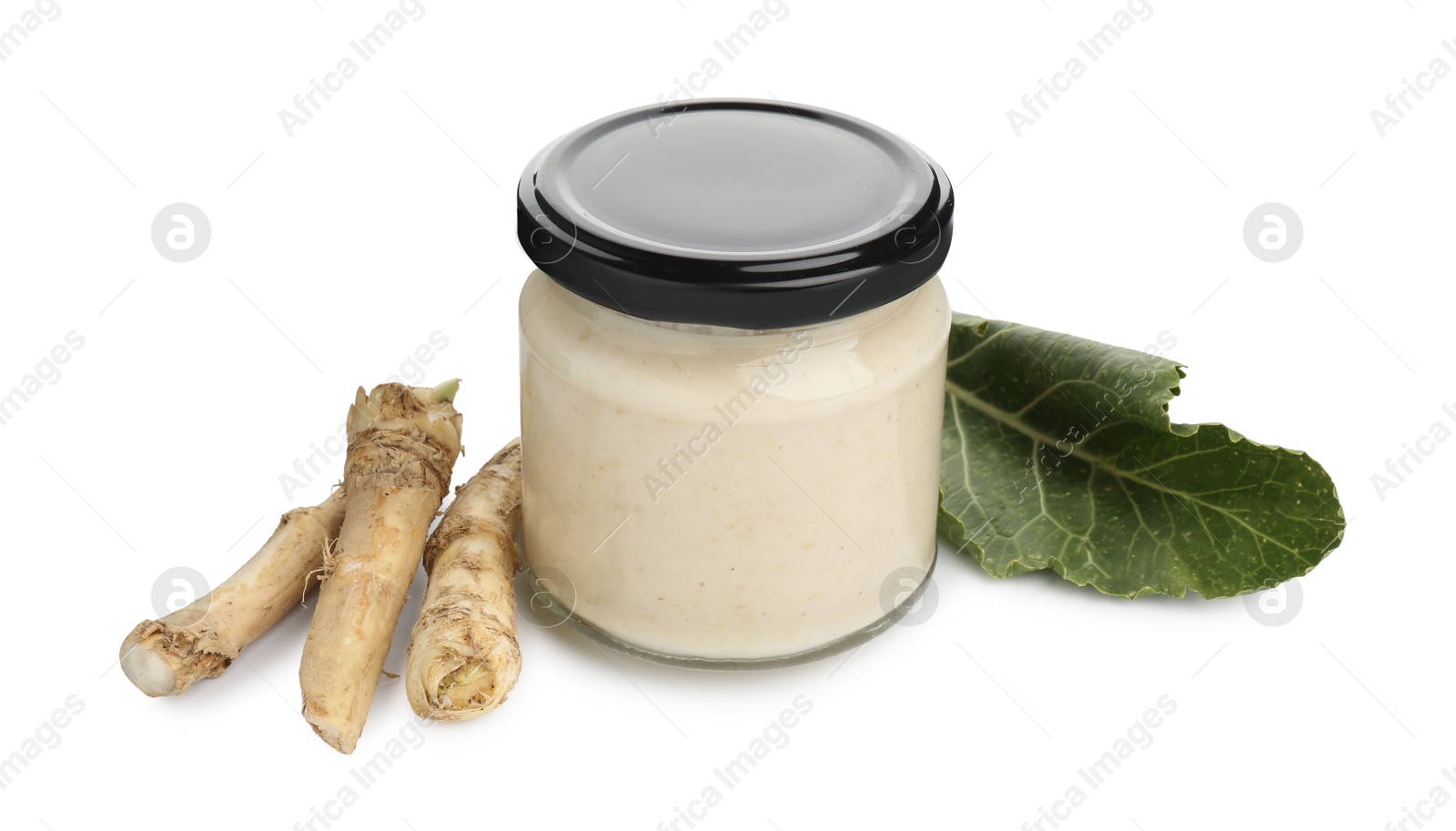 Photo of Tasty horseradish sauce in glass jar, leaf and roots isolated on white