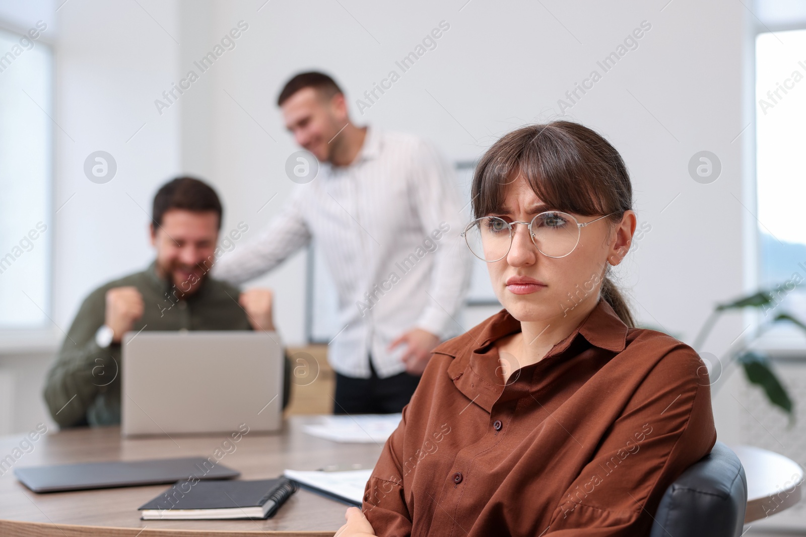 Woman feeling jealous of her colleague's success in office, selective focus Photo of Woman feeling jealous of her colleague's success in office, selective focus