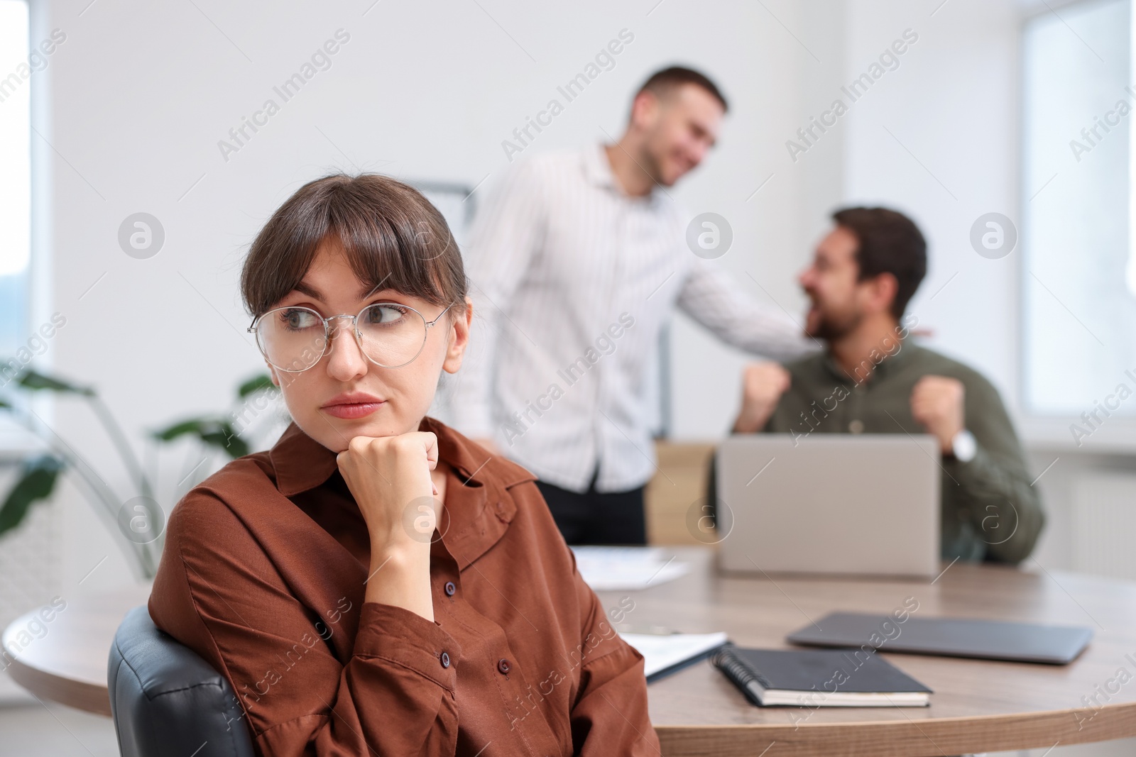 Woman feeling jealous of her colleague's success in office, selective focus Photo of Woman feeling jealous of her colleague's success in office, selective focus