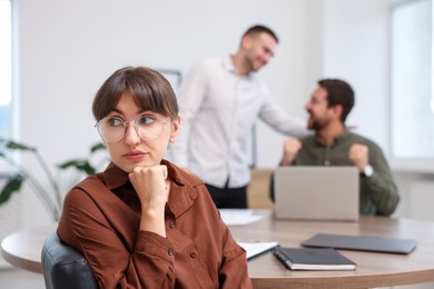 Photo of Woman feeling jealous of her colleague's success in office, selective focus