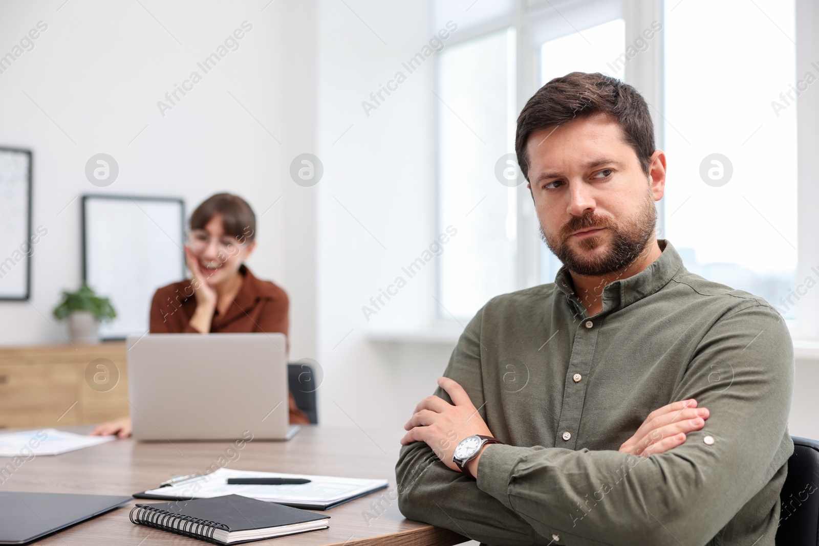 Photo of Man feeling jealous of his colleague's success in office, selective focus