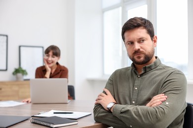 Photo of Man feeling jealous of his colleague's success in office, selective focus