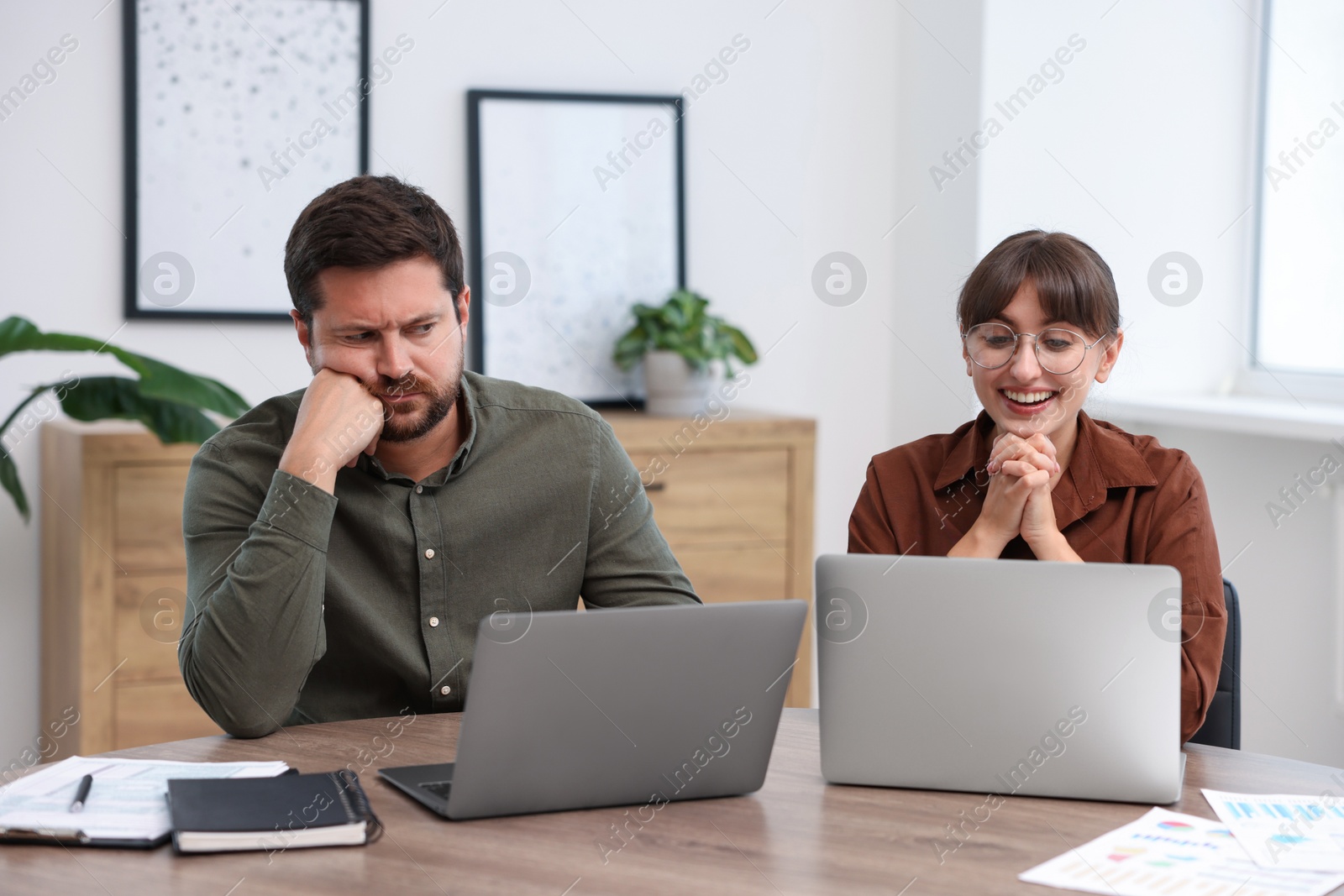 Man feeling jealous of his colleague's success in office Photo of Man feeling jealous of his colleague's success in office