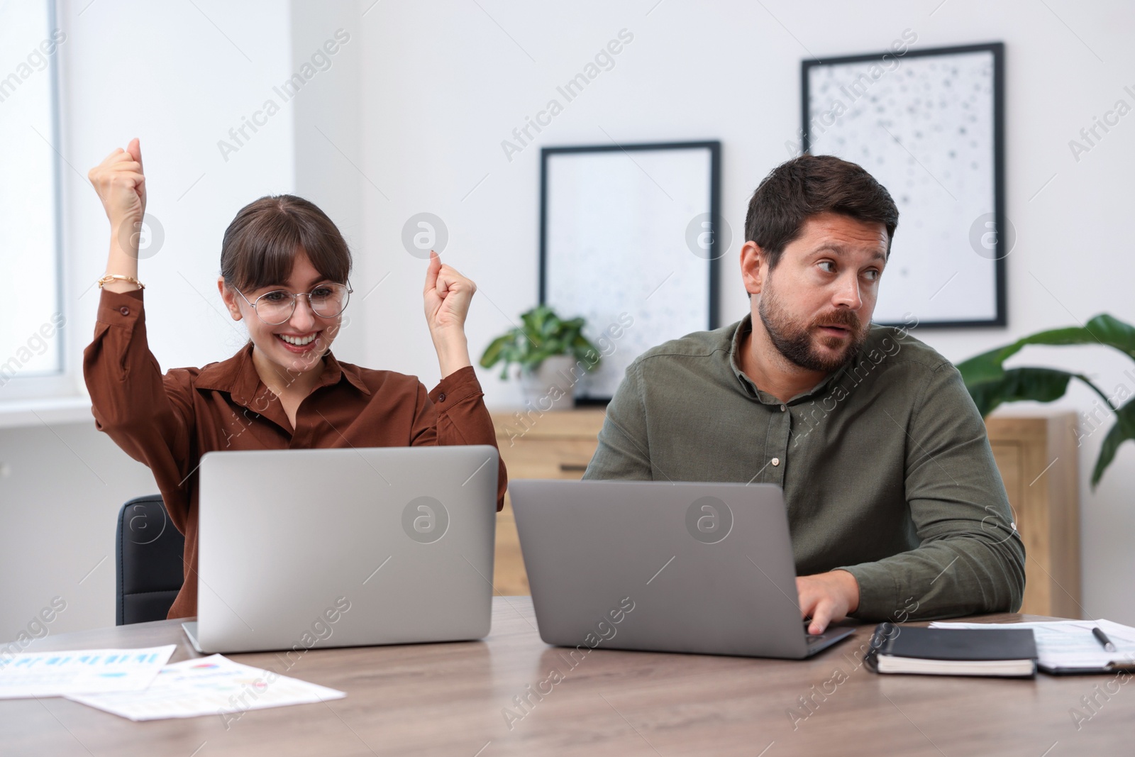 Man feeling jealous of his colleague's success in office Photo of Man feeling jealous of his colleague's success in office