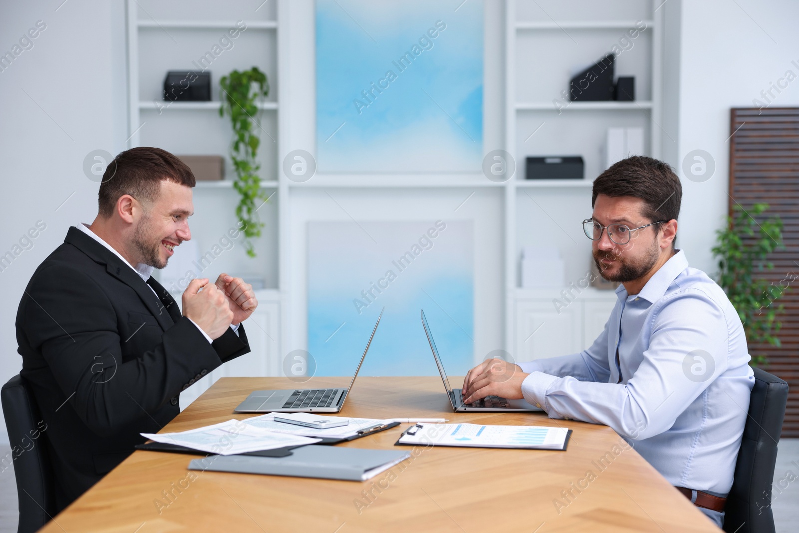 Man feeling jealous of his colleague's success in office Photo of Man feeling jealous of his colleague's success in office