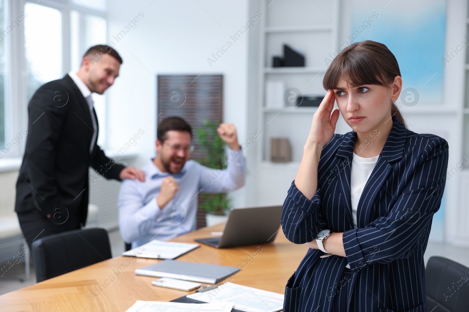 Photo of Woman feeling jealous of her colleague's success in office, selective focus