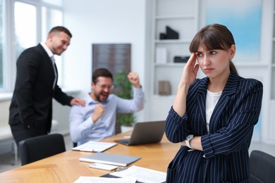 Photo of Woman feeling jealous of her colleague's success in office, selective focus
