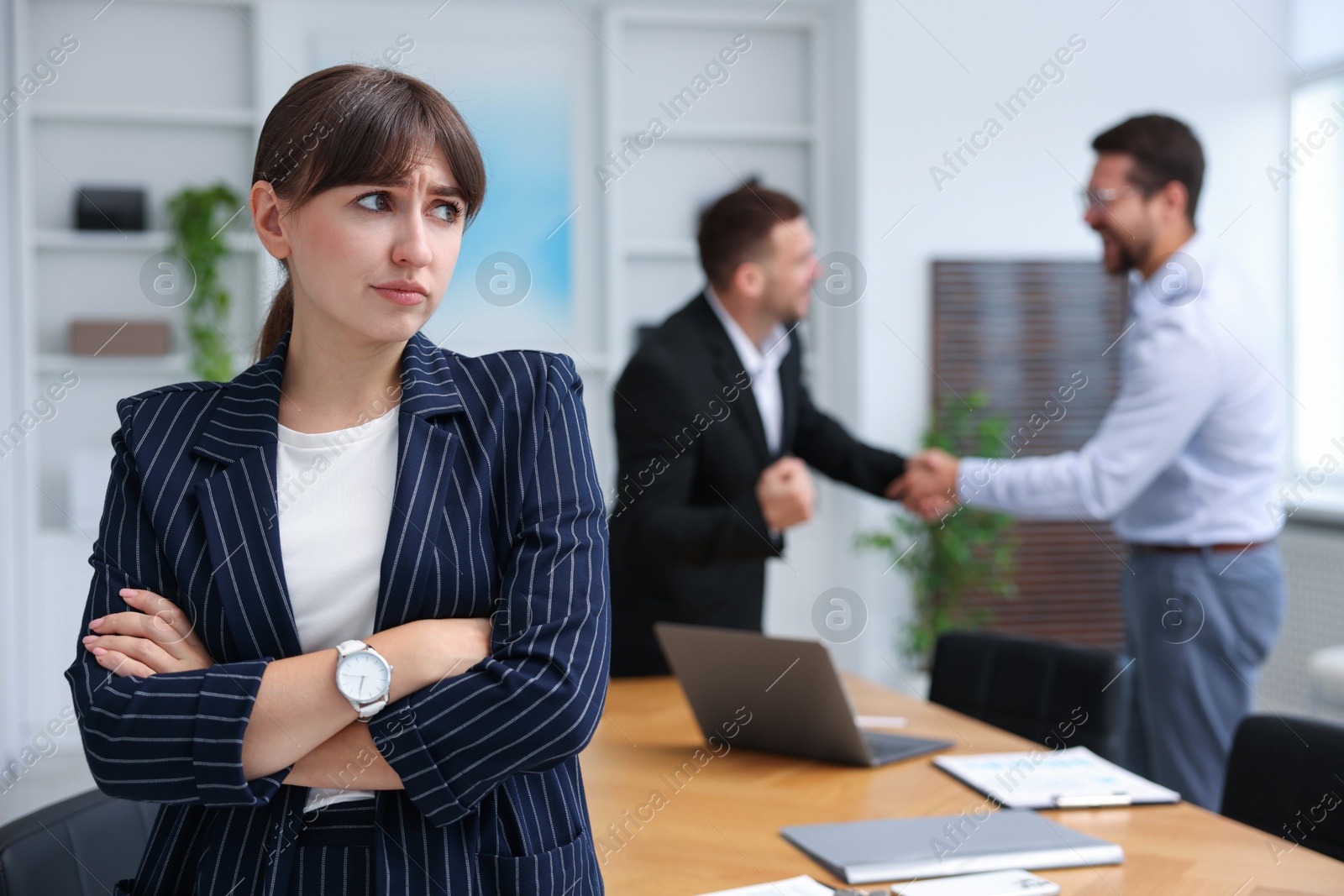 Photo of Woman feeling jealous of her successful colleague receiving congratulations in office, selective focus