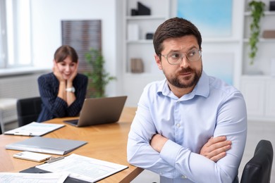 Photo of Man feeling jealous of his colleague's success in office, selective focus