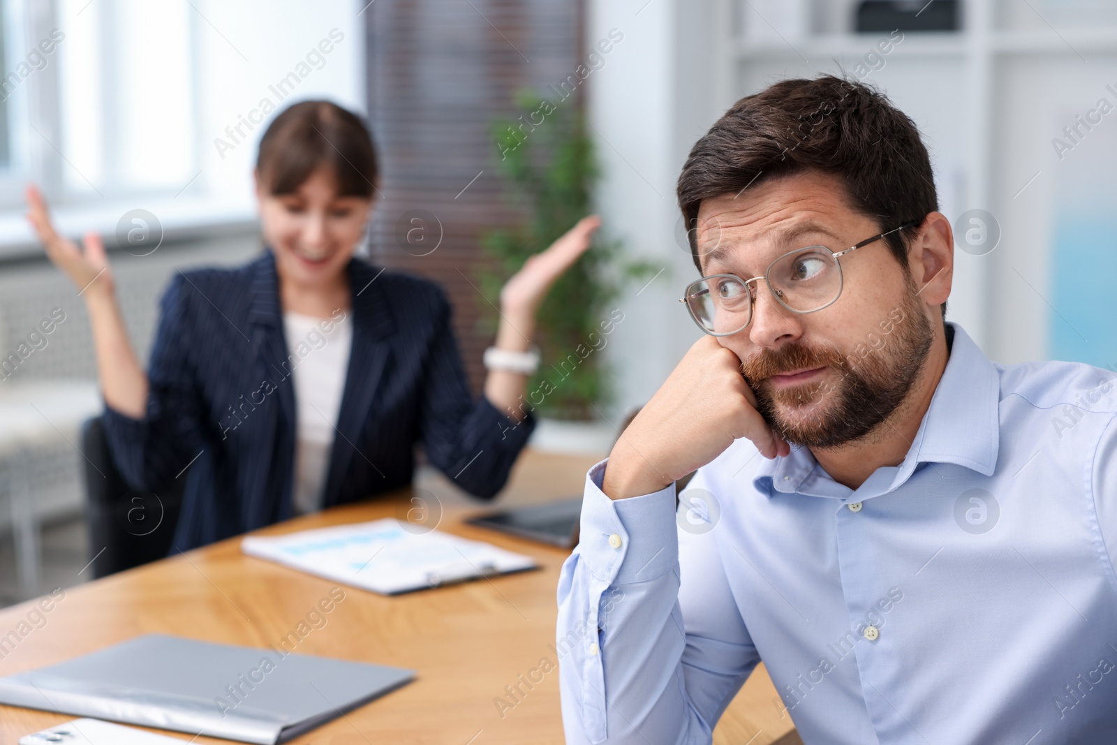 Man feeling jealous of his colleague's success in office, selective focus Photo of Man feeling jealous of his colleague's success in office, selective focus