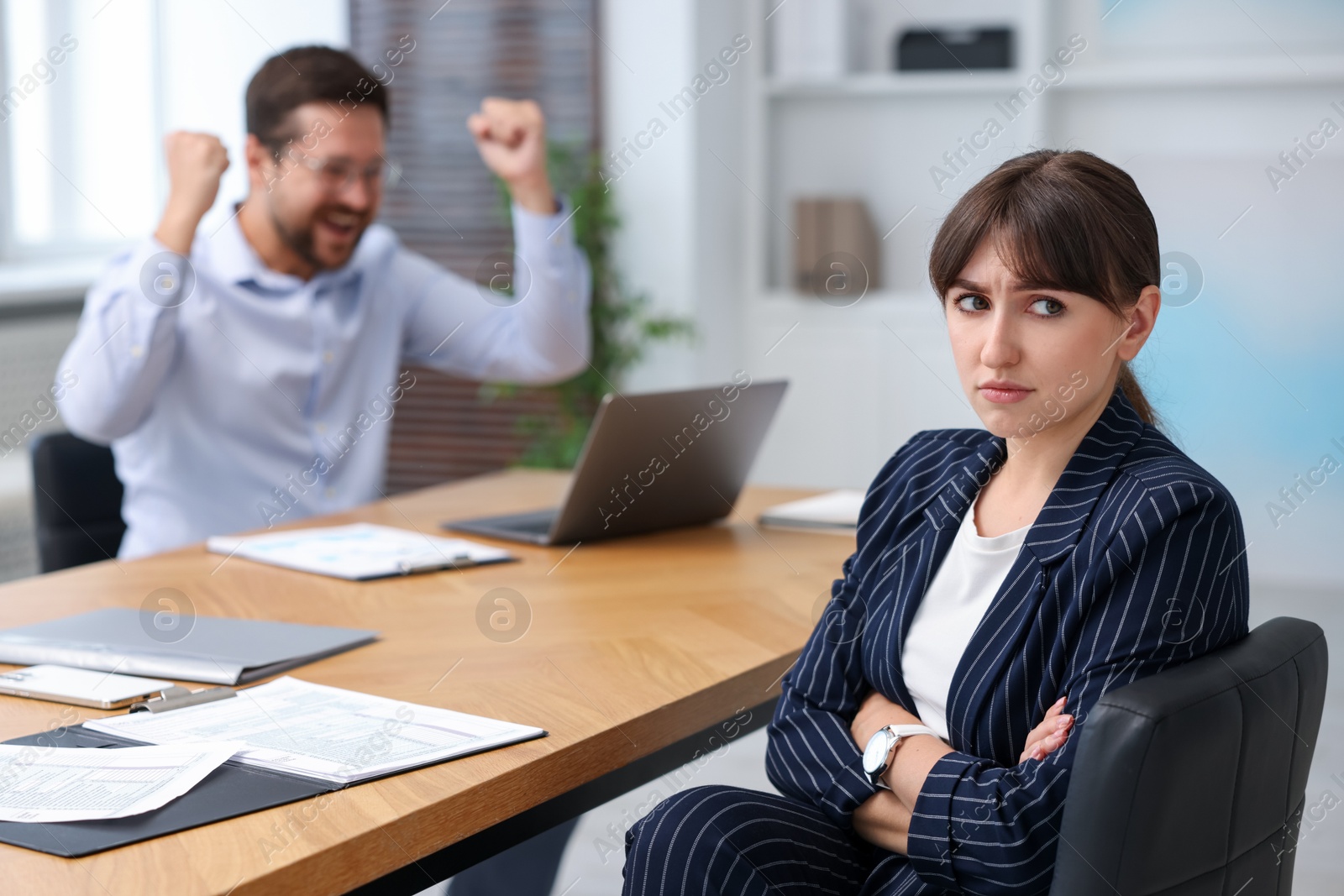 Woman feeling jealous of her colleague's success in office, selective focus Photo of Woman feeling jealous of her colleague's success in office, selective focus