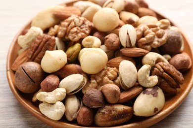Photo of Mix of different nuts on wooden table, closeup