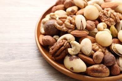 Photo of Mix of different nuts on wooden table, closeup. Space for text