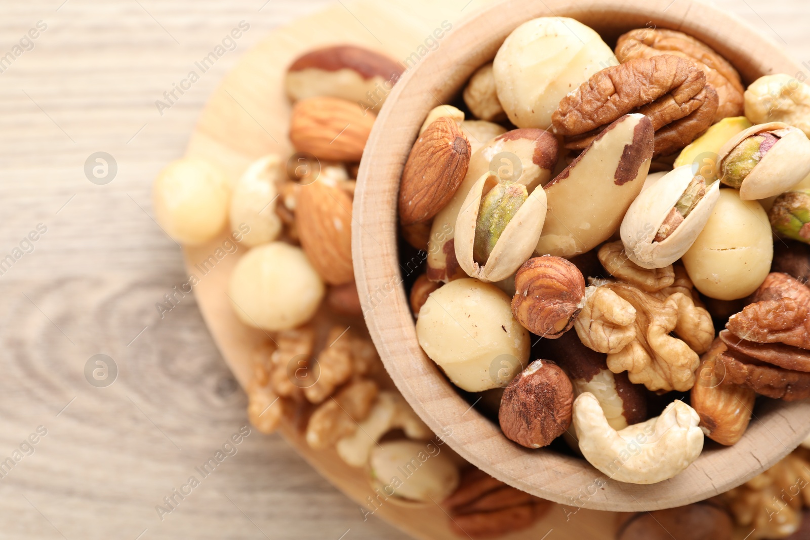 Photo of Mix of different nuts in bowl on table, top view. Space for text