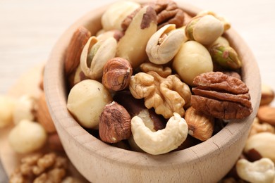 Photo of Mix of different nuts in bowl on table, closeup