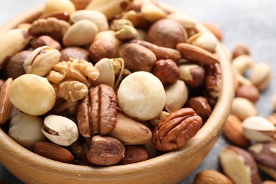 Photo of Mix of different nuts in bowl on table, closeup