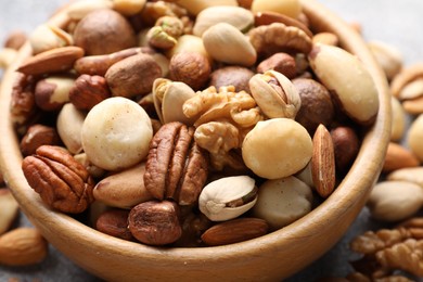 Photo of Mix of different nuts in bowl on table, closeup