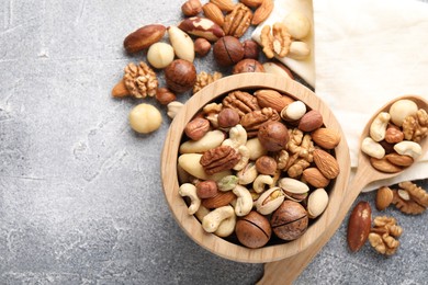 Photo of Mix of different nuts on grey textured table, flat lay. Space for text