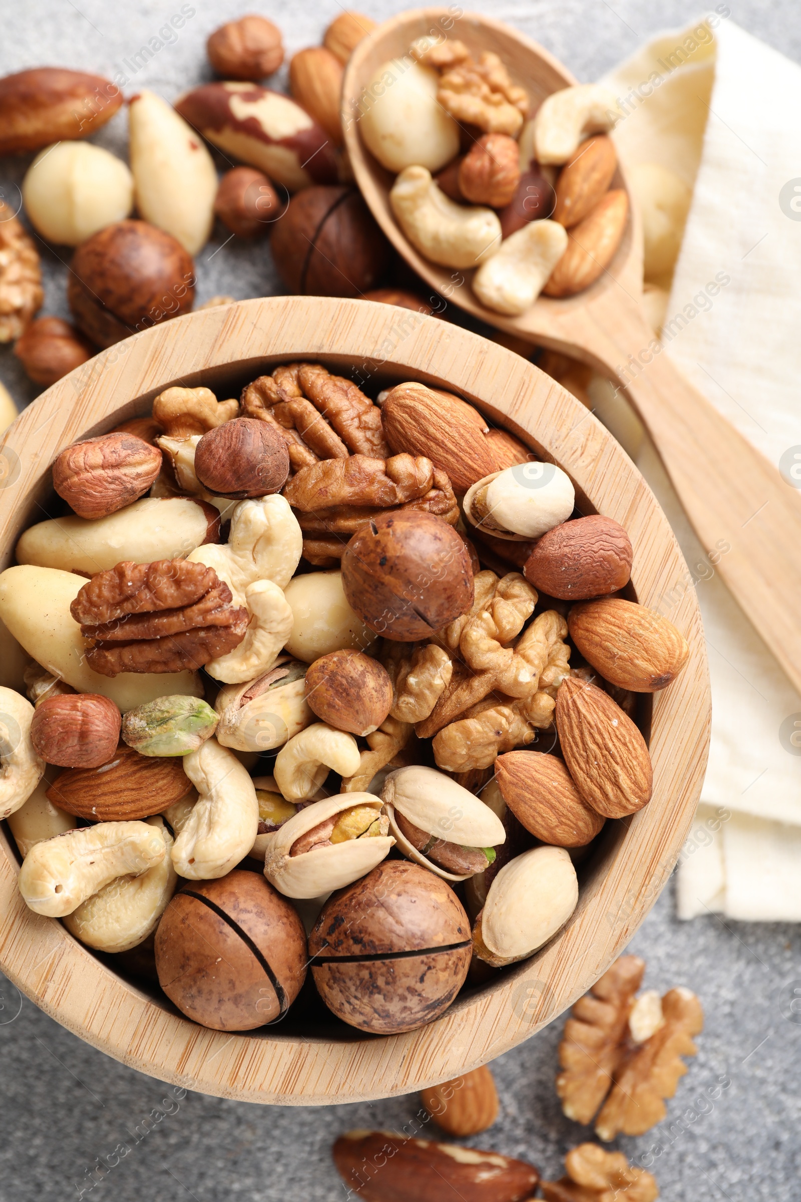 Photo of Mix of different nuts on grey table, flat lay