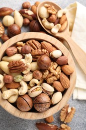 Photo of Mix of different nuts on grey table, flat lay