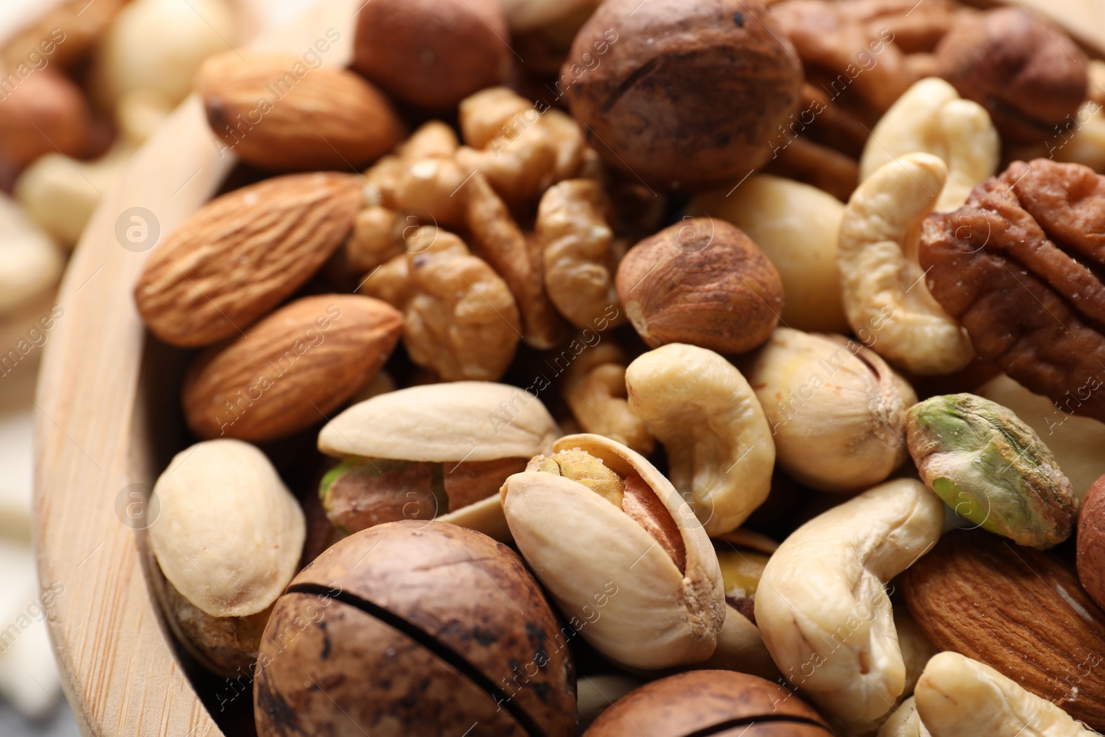 Photo of Mix of different nuts in bowl on table, closeup
