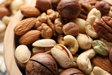 Photo of Mix of different nuts in bowl on table, closeup