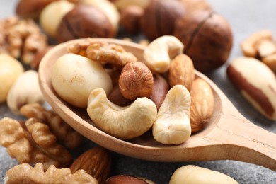 Photo of Mix of different nuts on grey table, closeup