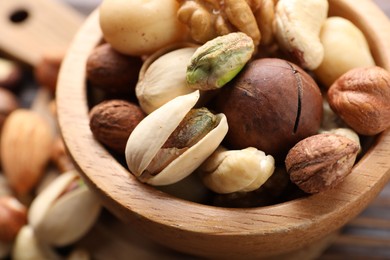 Photo of Mix of different nuts in bowl on table, closeup