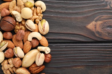 Photo of Mix of different nuts on wooden table, flat lay. Space for text