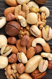 Photo of Mix of different nuts on wooden table, flat lay