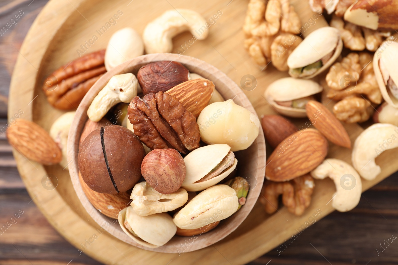 Photo of Mix of different nuts on wooden table, top view