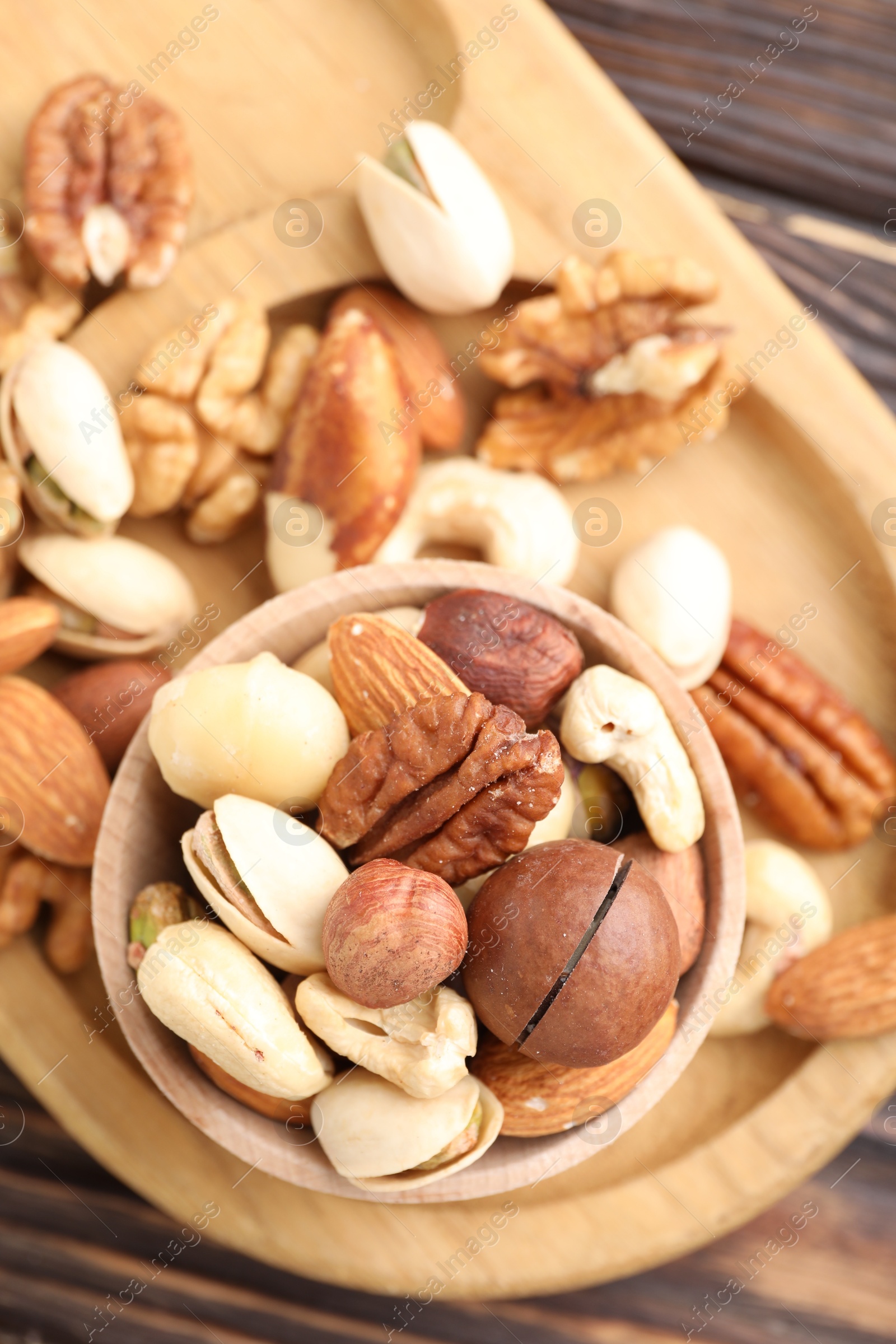 Photo of Mix of different nuts on wooden table, top view