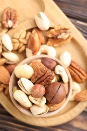 Photo of Mix of different nuts on wooden table, top view