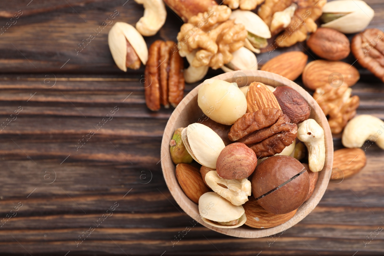 Photo of Mix of different nuts on wooden table, flat lay. Space for text