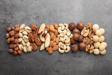 Photo of Mix of different nuts on grey table, flat lay