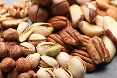 Photo of Mix of different nuts on grey table, closeup
