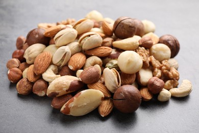 Photo of Mix of different nuts on grey table, closeup