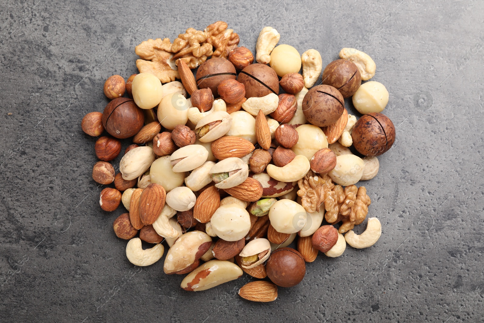 Photo of Mix of different nuts on grey table, flat lay