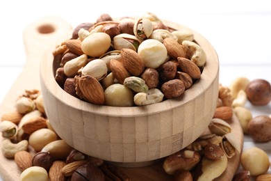 Photo of Mix of different nuts in bowl on table, closeup