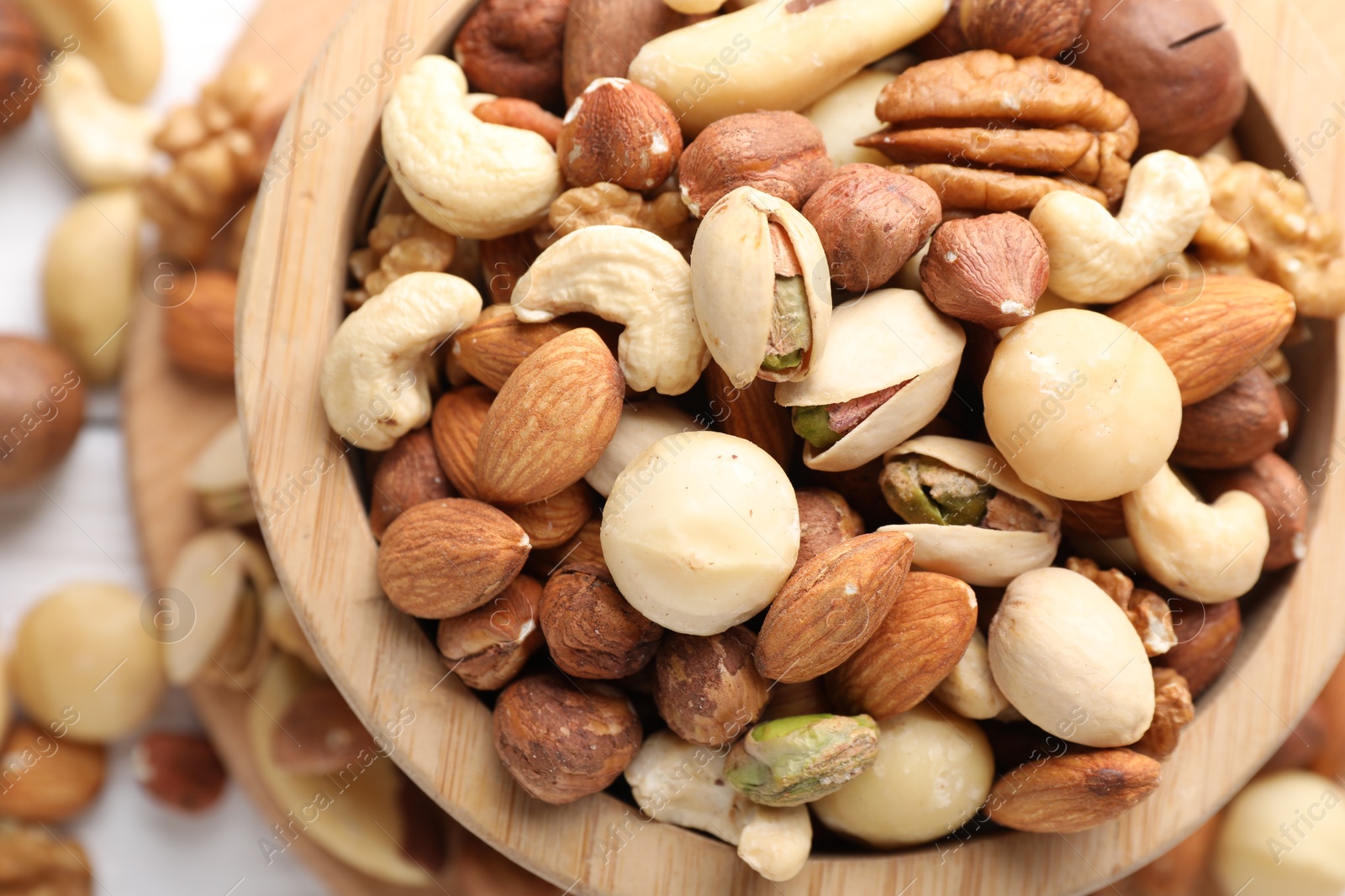 Photo of Mix of different nuts in bowl on table, top view