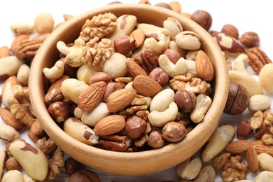 Photo of Mix of different nuts in bowl on table, closeup