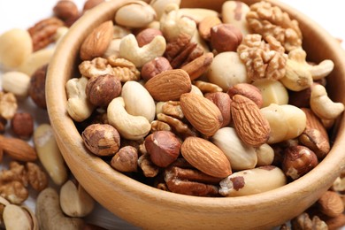 Photo of Mix of different nuts in bowl on table, closeup