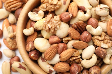 Photo of Mix of different nuts in bowl on table, top view