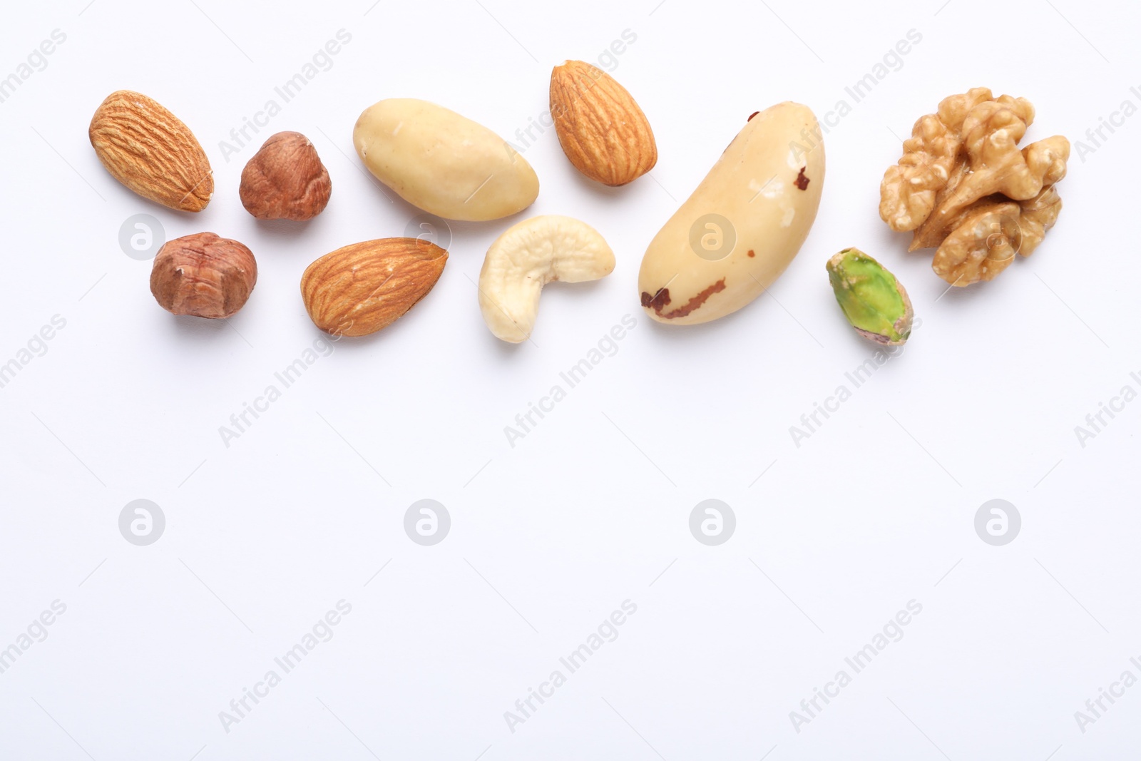 Photo of Mix of different nuts on white background, flat lay. Space for text