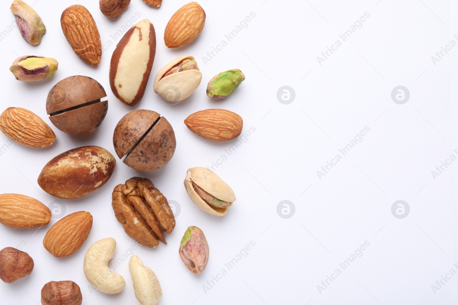 Photo of Mix of different nuts on white background, flat lay. Space for text