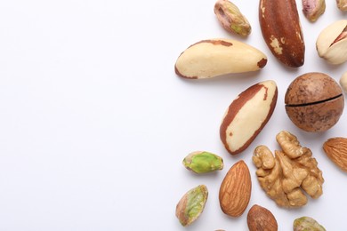 Photo of Mix of different nuts on white background, flat lay. Space for text